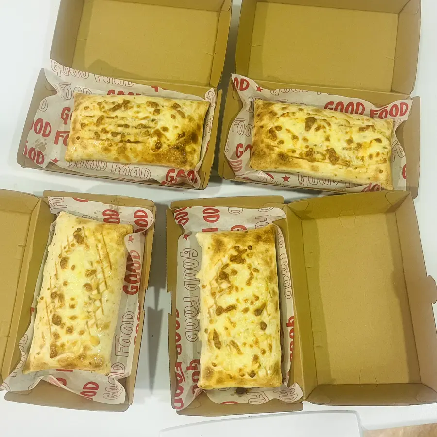 Cuatro french tacos gratinados en sus cajas para llevar