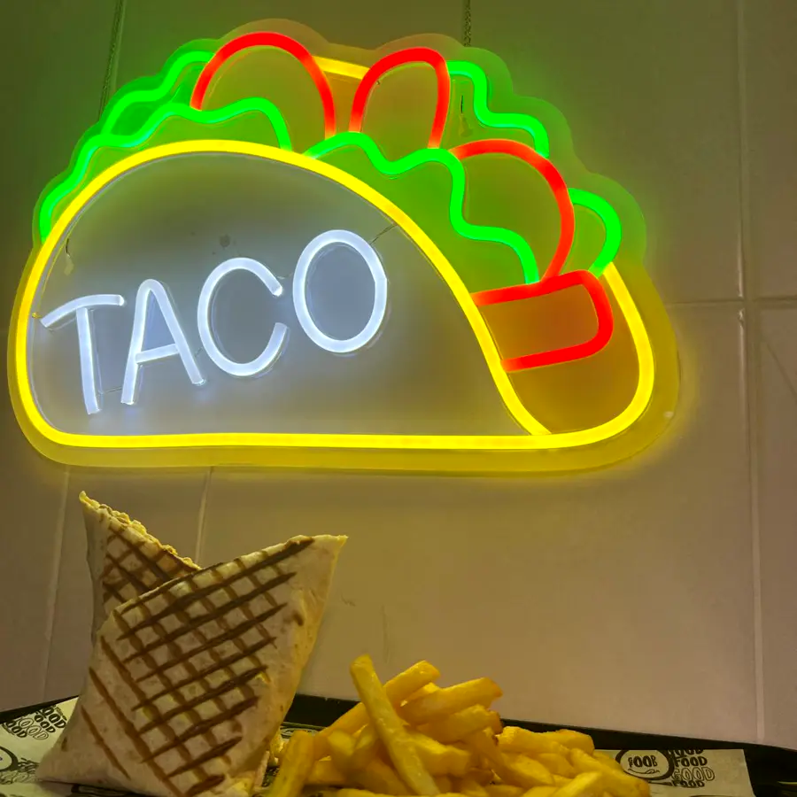 French tacos a la plancha con patatas bajo el neón TACO del local