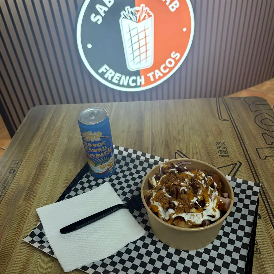 El logo de Sabor Kebab en la pared y un bowl en la mesa